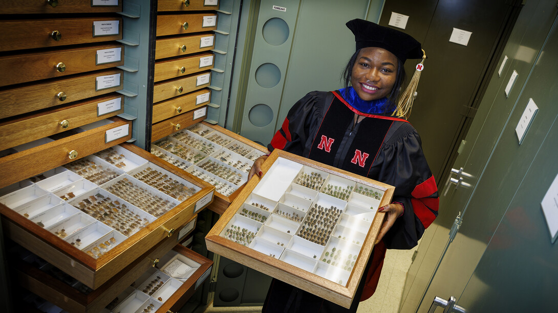 Blessing Ademokoya, a doctoral candidate in entomology, poses with the state museum’s collection of stink bugs. 