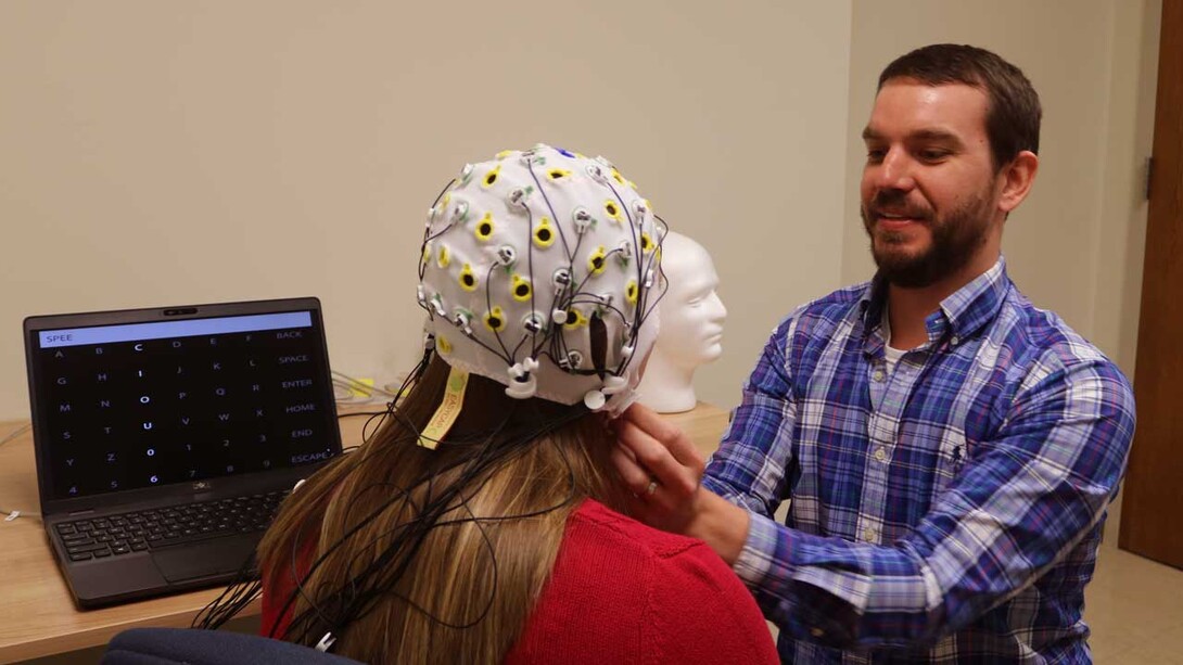 Kevin Pitt, assistant professor of special education and communication disorders, prepares an EEG cap for use on a P300 speller device (Photo by Kelcey Buck, Special Education and Communication Disorders). 