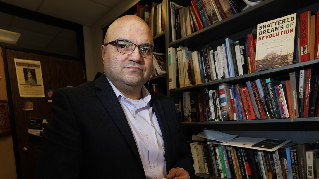 Bedross Der Mattossian is photographed in his office, among many volumes written about genocides spanning centuries.