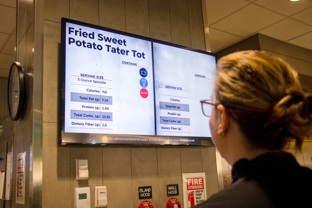 Customer views the menu board in the Cather Dining Center.