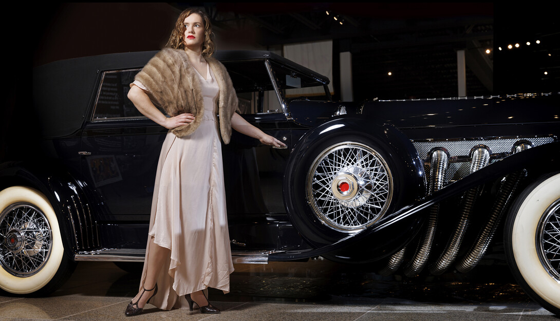 Anna Kuhlman evokes Hollywood glamour in this long 30s-style gown features bias cut panels and flowing sleeves in a soft pink. Paired with a vintage fur stole and T-strap heels.She poses next to a 1930 Duesenberg Model J at the Speedway Motors Museum of Speed. Kuhlman, who received her masters degree in May, researched fashion in the 1930s both in film and what was available in Nebraska.