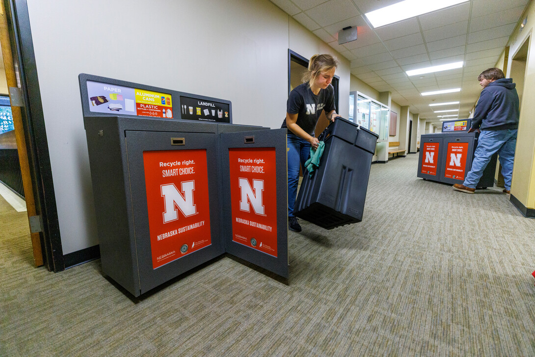 people placing new recycling containers in buildings