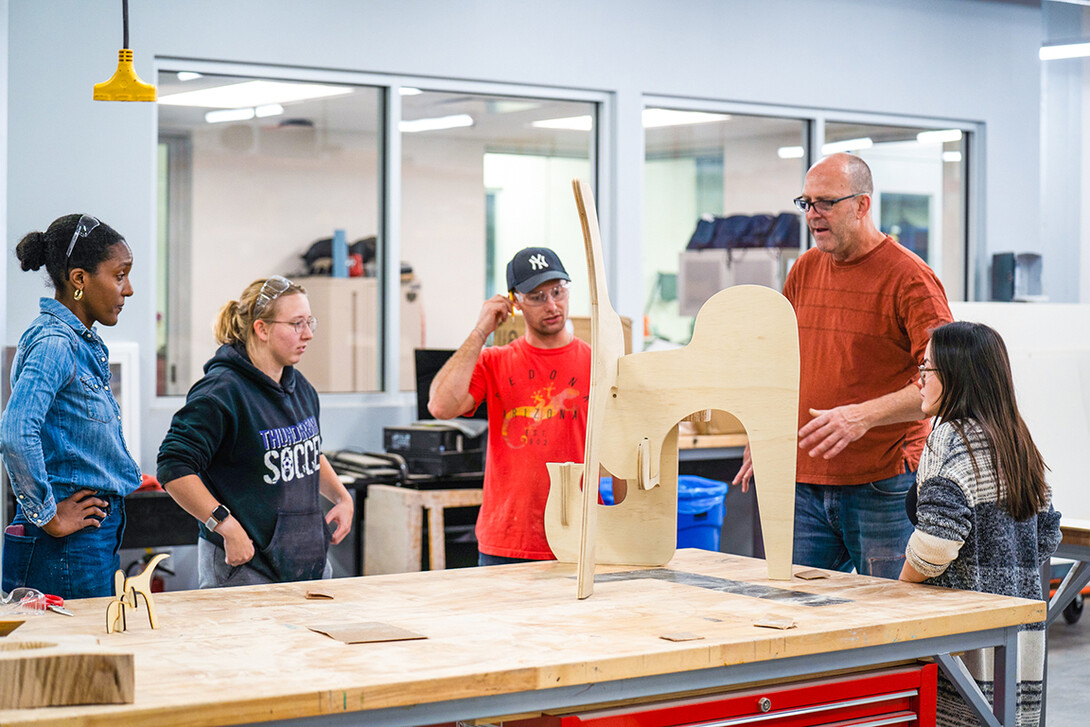 Aziza Cyamani, Elizabeth Loftus, Thomas Gerees, Iowa State Professor Chis Martin, and Caroline Gomel look over their almost finished project.