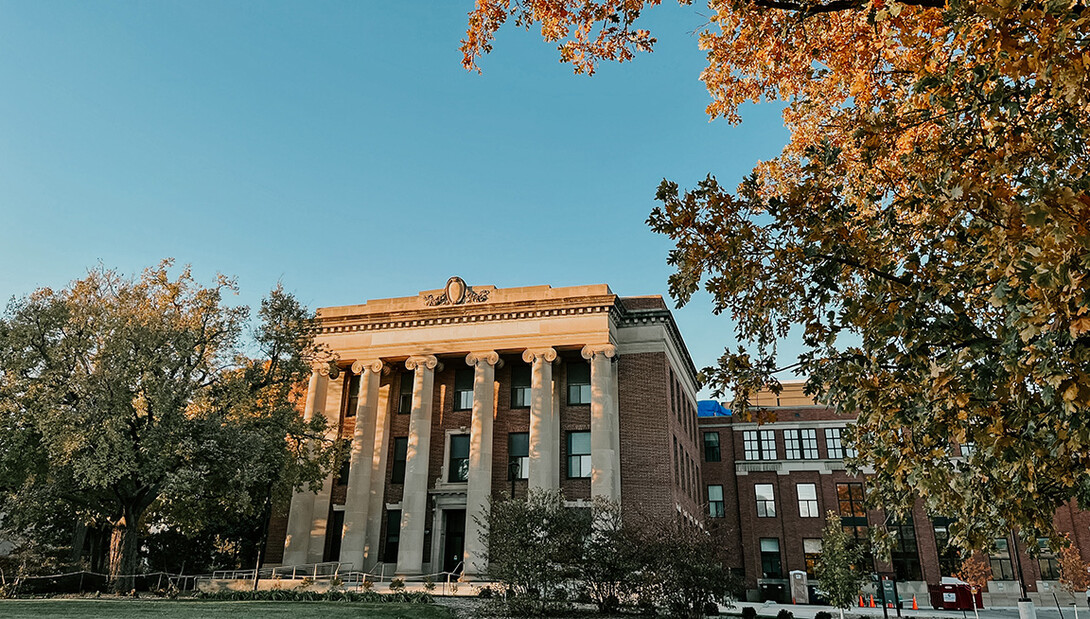 Pound Hall is framed by gold leaves and a blue sky.