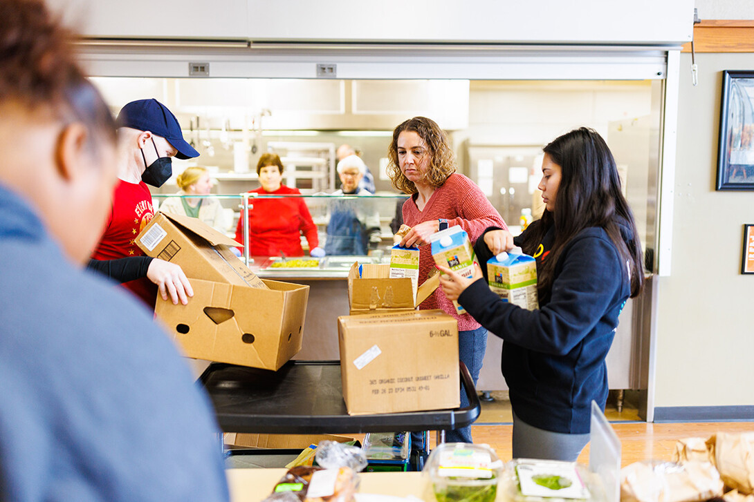 Rev. Zac Wolfe, left, Rebecca Baskerville, Associate Director for Experiential & Global Learning, and Bree Bell, a freshman in marketing from Omaha, unload food for the lunch crowd at Matt Talbot.