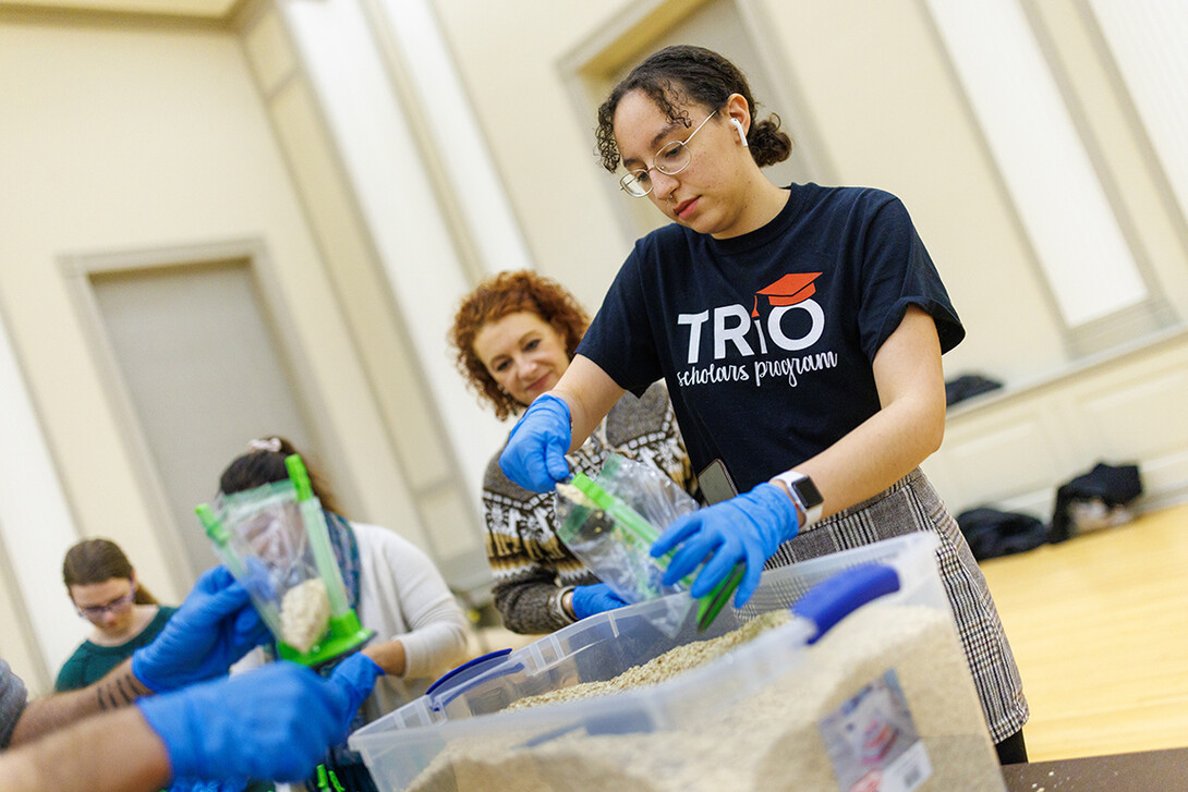 Mona Miller, a sophomore from Omaha, scoops oatmeal into bags as part of MLK week events.