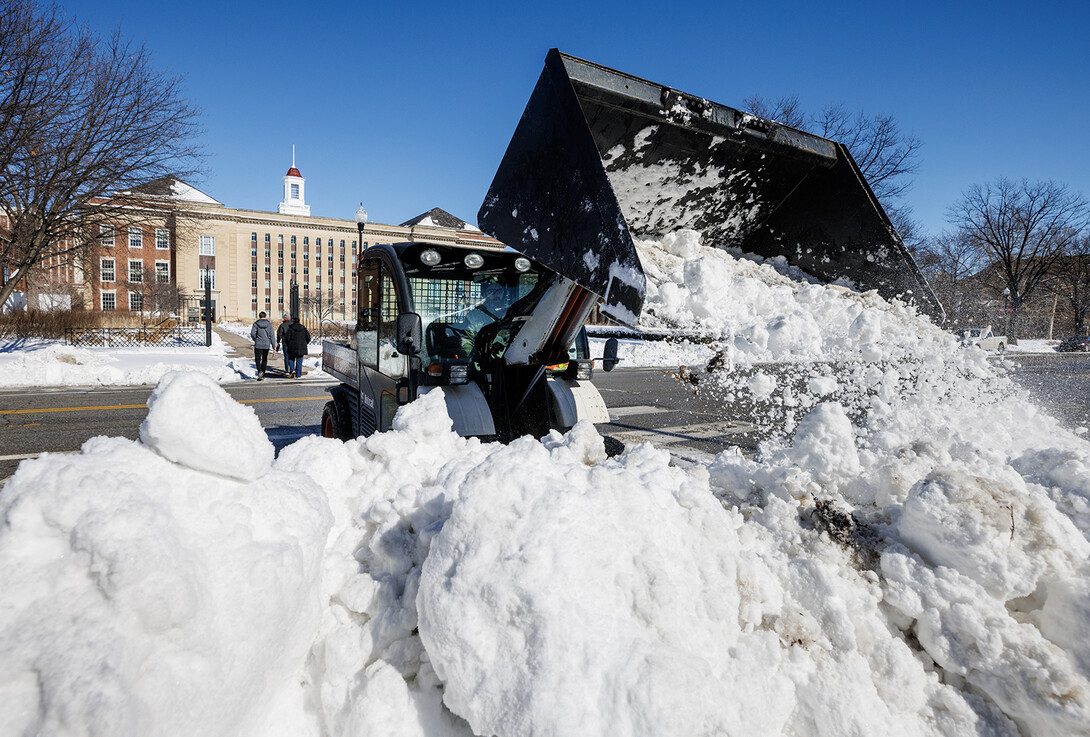 A Landscape Services worker uses a Bobcat tractor to shift snow on Feb. 17.