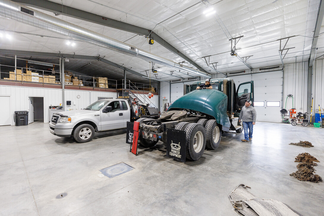 Jeff Hornung talks with employee Kelton Walz in the shop as Walz works to recondition 2019 Kenworth for resale.