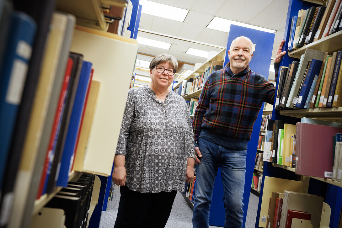 Joanie Barnes (left) and Tom McFarland stand in the stacks of Love Library.