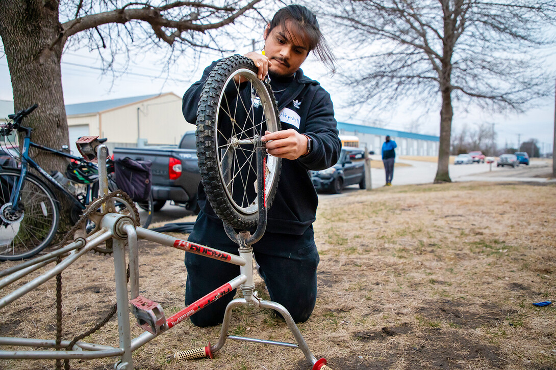 Nebraska Engineering’s Alejandro Marquez works on removing a tire from a donated ride at the Lincoln Bike Kitchen.