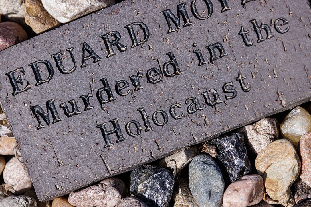 A brick rests in the garden with the name of a person murdered in the Holocaust.  