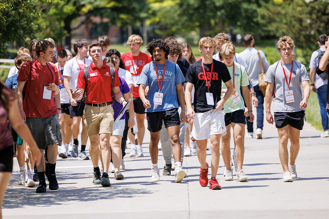 A New Student Orientation Leader takes a group of incoming students on a walking tour of campus June 7.