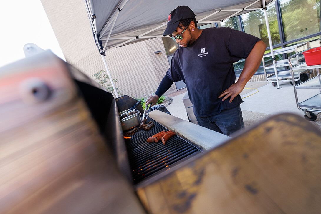 Sean Jones, a line cook with dining services, flips short ribs on the grill before serving them to customers. 