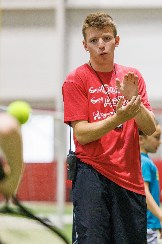 Carson Linquist, a senior from Omaha, encourages a camper in the tennis relay.