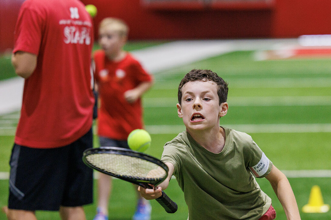 Felix Tabor tries to not let his tennis ball get away from him in the tennis relay. Campers had to bounce a ball on their racket walking backwards and forwards.