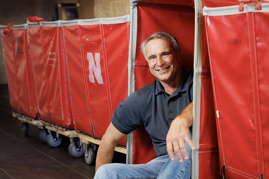 Larry Shippen sits near a red container used for student move-in