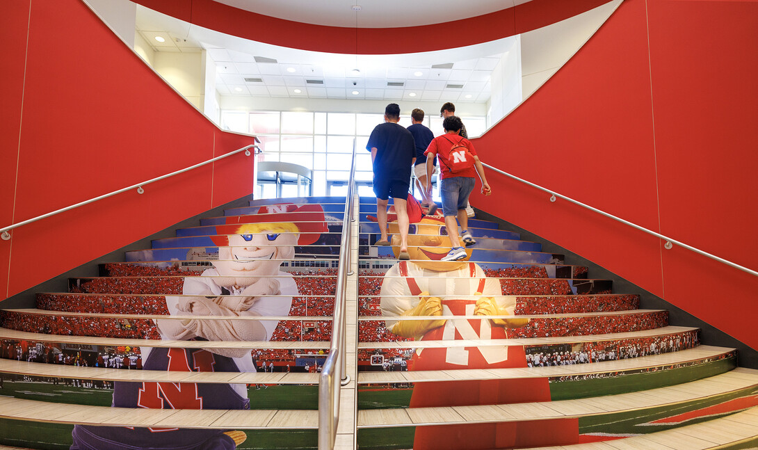 Students walk up the stairs in Nebraska Union Aug 16. The stairs were updated with new decals depicting Herbie Husker and Lil Red.