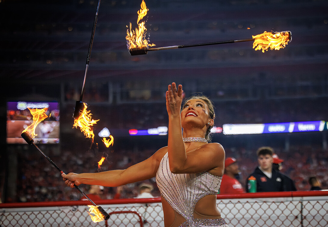 Steffany Lien twirls batons of fire at the Husker football game halftime show.