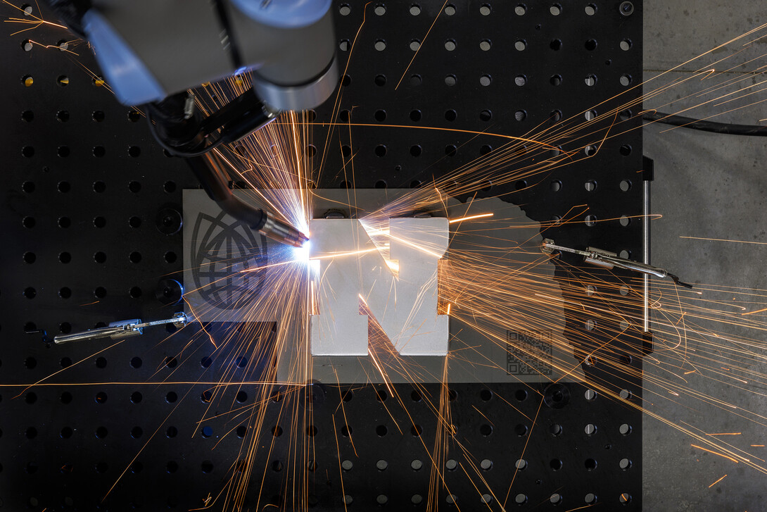 A robotic welder works around a Nebraska "N" at Nebraska Innovation Studio