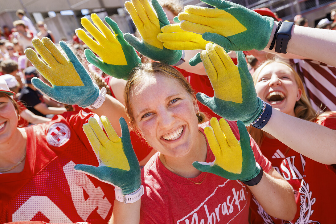 Carrie Wehrman is surrounded by yellow and green corn gloves