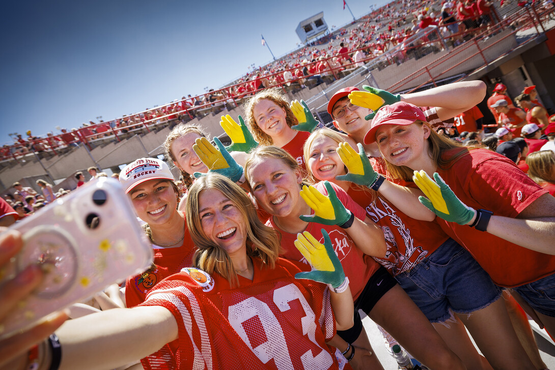 Carrie Wehrman and friends take a group photo wearing Wehrman's creation during the game against UTEP.