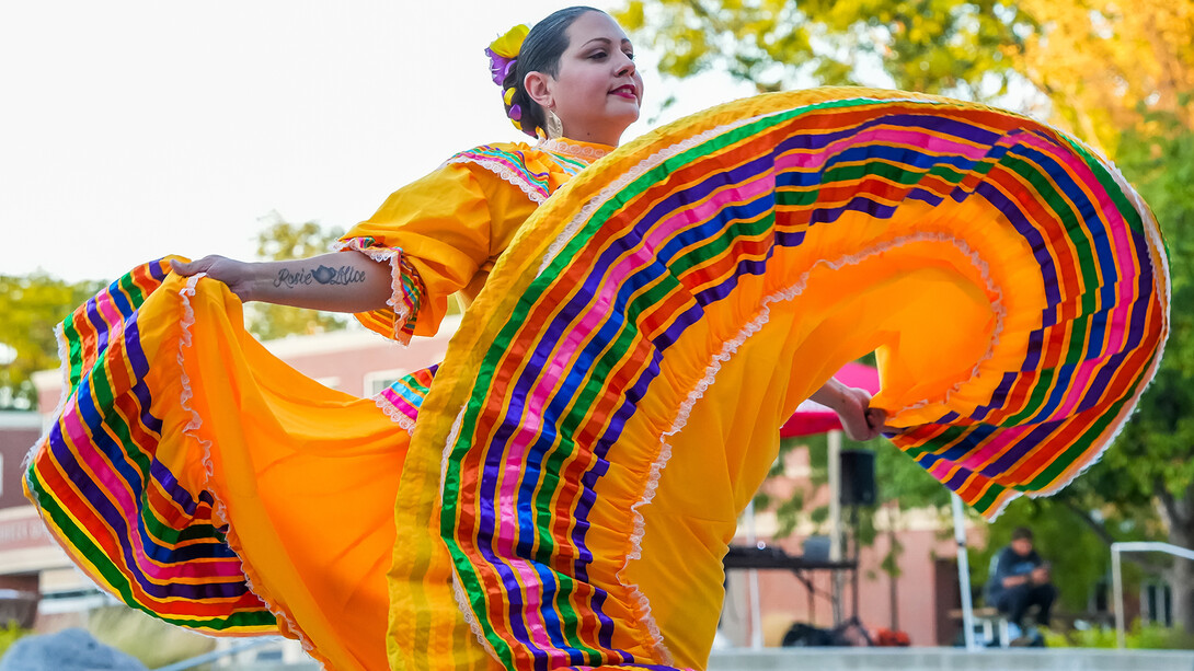A dancer from Sangre Azteca twirls her yellow and multi-colored striped dress during Fiesta on the Green on Sept. 27.