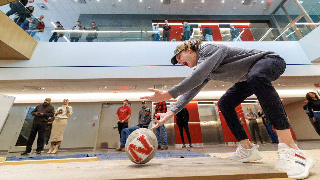 Quinn Gossett, a junior construction management major, rolls his ball down the lane with enthusiasm during the Concrete Bowling Competition in the Kiewit Hall Basement on Dec. 11.