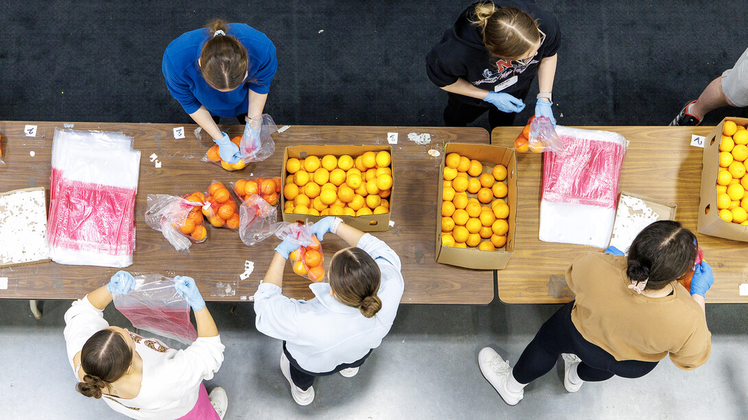 University of Nebraska–Lincoln students place oranges in bags during a volunteer project at the Food Bank of Lincoln.