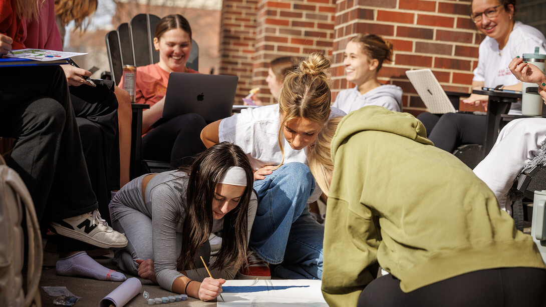 Alpha Chi Omega sisters are all smiles as they work together on the patio in front of their sorority house on Feb. 25. The university community shook off winter’s grip this week as temperatures climbed to spring-like levels.