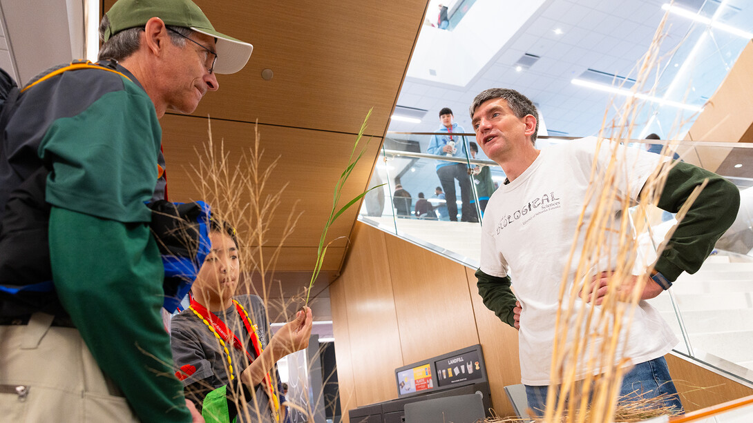 Chad Brassil (right), associate professor of biological sciences, talks about native prairie grasses with Gordon Wood during the Science Olympiad National Tournament’s STEM Expo on May 23.