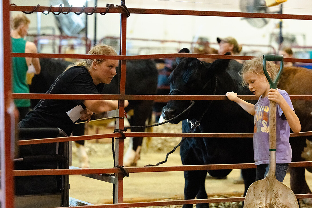 Addy Bates, 17, listens to eight-year-old Sloane Murdoch in the cattle barn at the Otoe County Fair in Syracuse on Thursday, July 31. Murdoch is a 4-H Clover Kid and isn't able to show livestock yet. She wanted to know more about Bates's cows.