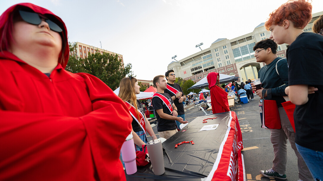 First-year students (from right) Kai White and Eddy Alcaid chat with members of the Innocents Society during the Big Red Welcome Street Festival on Aug. 24.