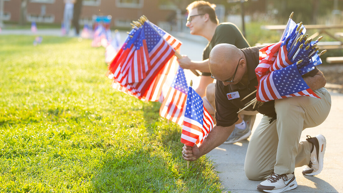 Volunteers place flags in the ground as part of a 9/11 observance.