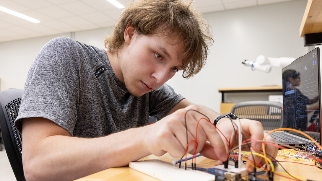 Student connecting wires as part of a robotics project.