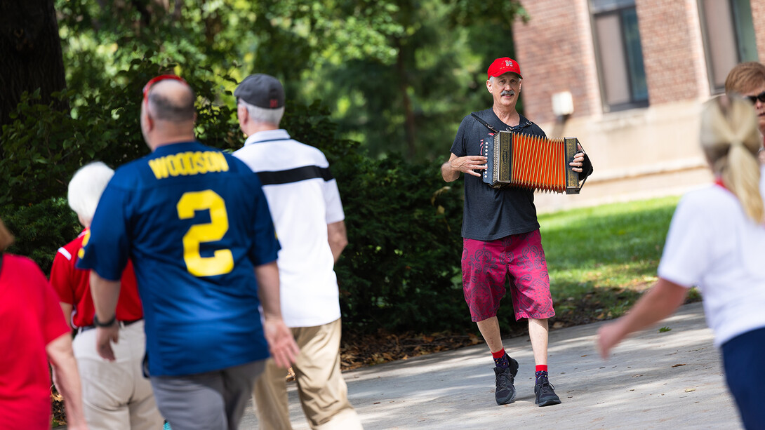 Accordion player Chris Sayre plays as fans walk by outside Sheldon Art Gallery.