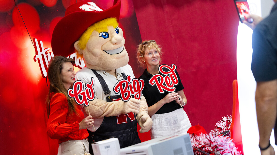 Employees taking a selfie with Herbie Husker