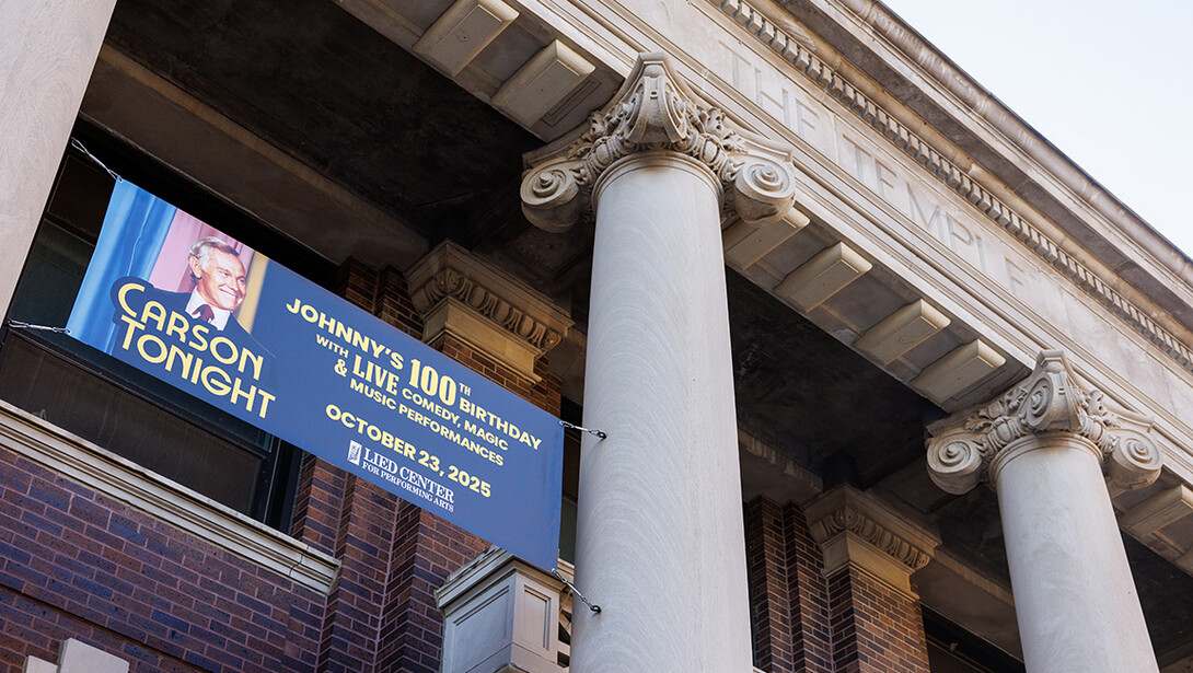 A sign advertising Carson Tonight hangs from the Temple Building. The event celebrates University of Nebraska alum Johnny Carson’s 100th birthday.