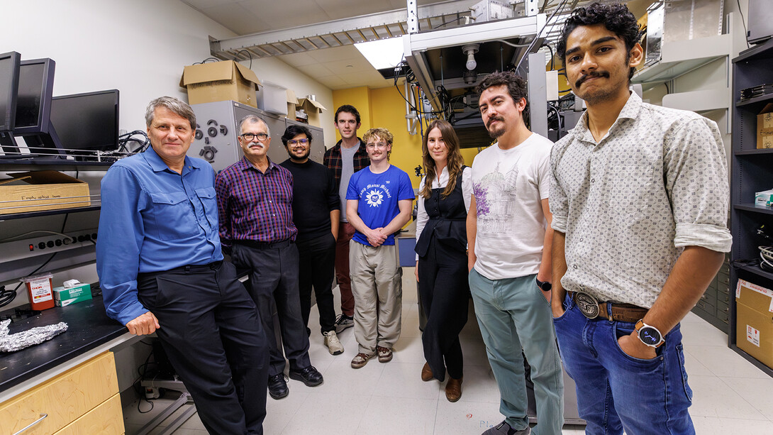 Herman Batelaan (left) stands with student researchers, (starting second from left) Marie Rioux, Ryan O’Donnell, Wyatt Balters, Raul Puente, Arjun Mohanan, Sajid Raihan Akash and Marlon Weiss. Batelaan’s quantum optics research has been honored by the American Physical Society.