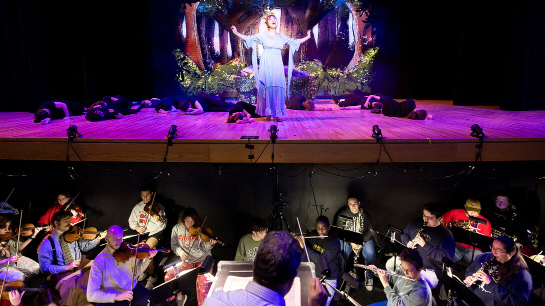 A singer performs on stage as a symphony plays in Kimball Recital Hall.