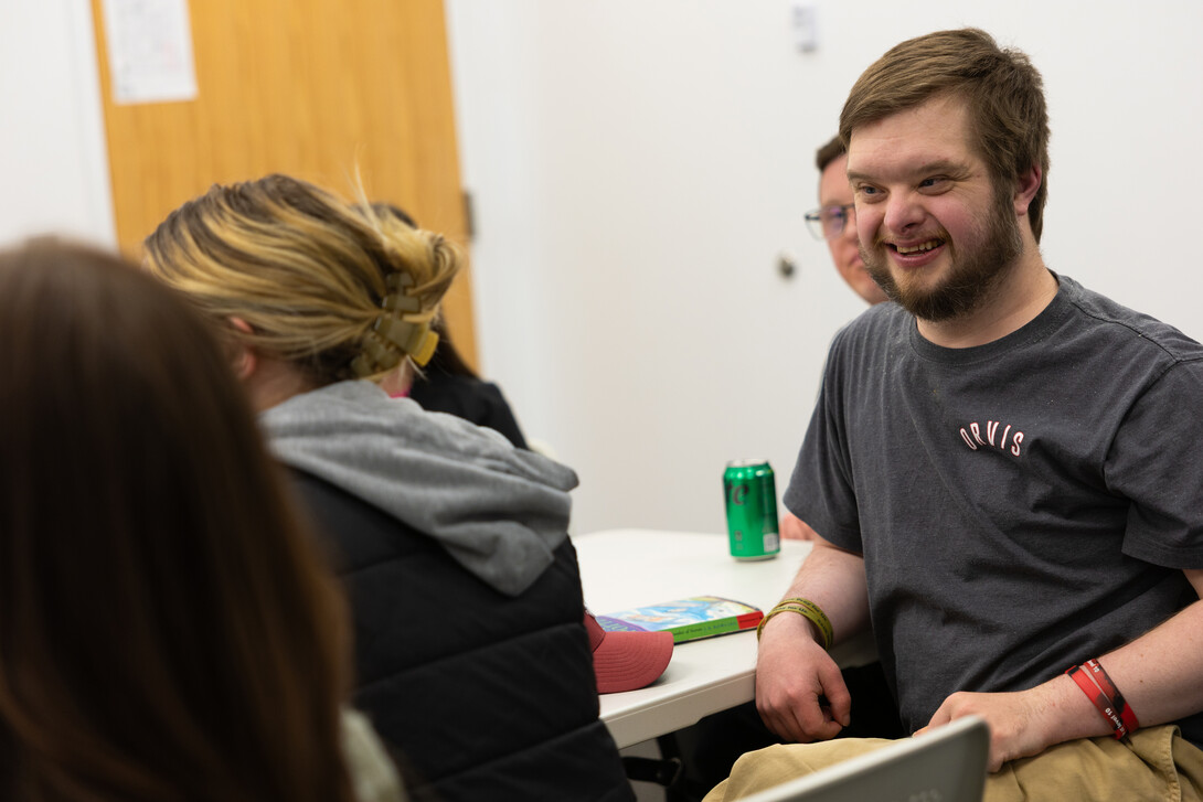A man smiles at a table with his book club.