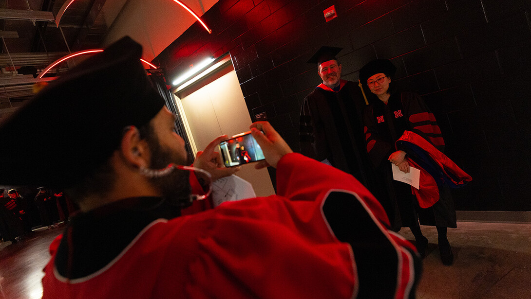Gautham Takoo, a research technologist in the Department of Agronomy and Horticulture, snaps a photo of Sunhyoung Lee and her adviser, James Boviard, professor of educational psychology. Lee graduated with her doctorate in educational psychology.