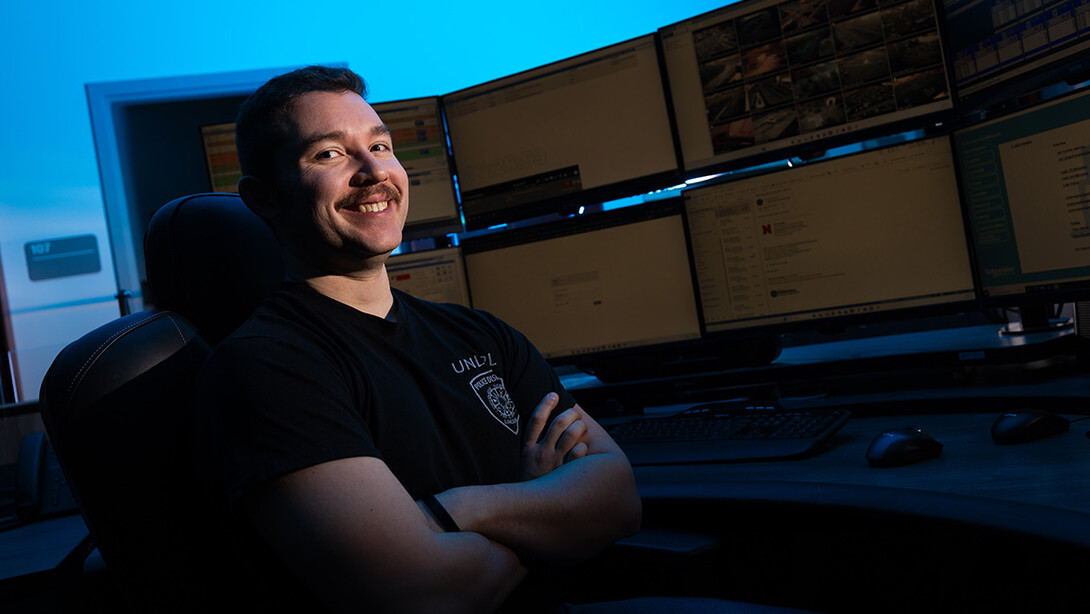 Adam Santee sits at one of the desks used by dispatch at the University of Nebraska–Lincoln Police Department offices. Santee started working in dispatch as a student and is now dispatch supervisor.