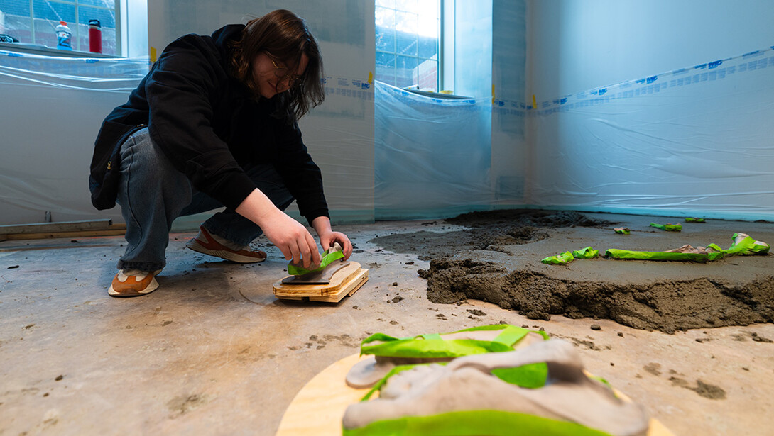 Isaac Regier, lead and design coordinator for the Frontier Tech Lab, sets down one of the "bones" the lab 3D printed for a new fossil dig in the redesigned Marx Science Discovery Center at Morrill Hall.