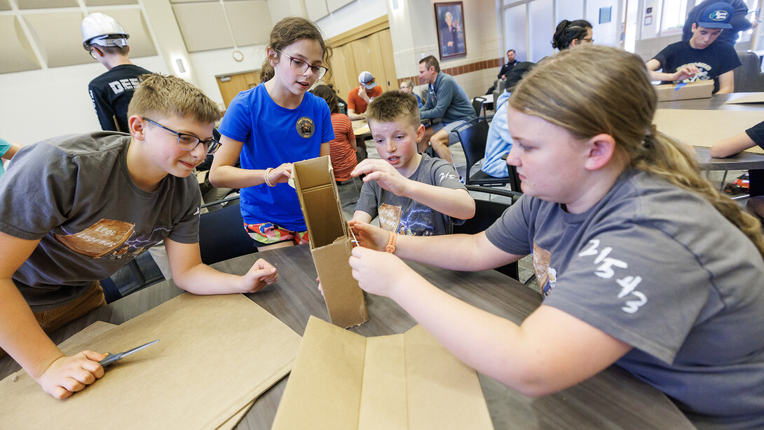 Four middle school students solving a problem as part of the "Changing the World in the Raikes School" event on March 20.