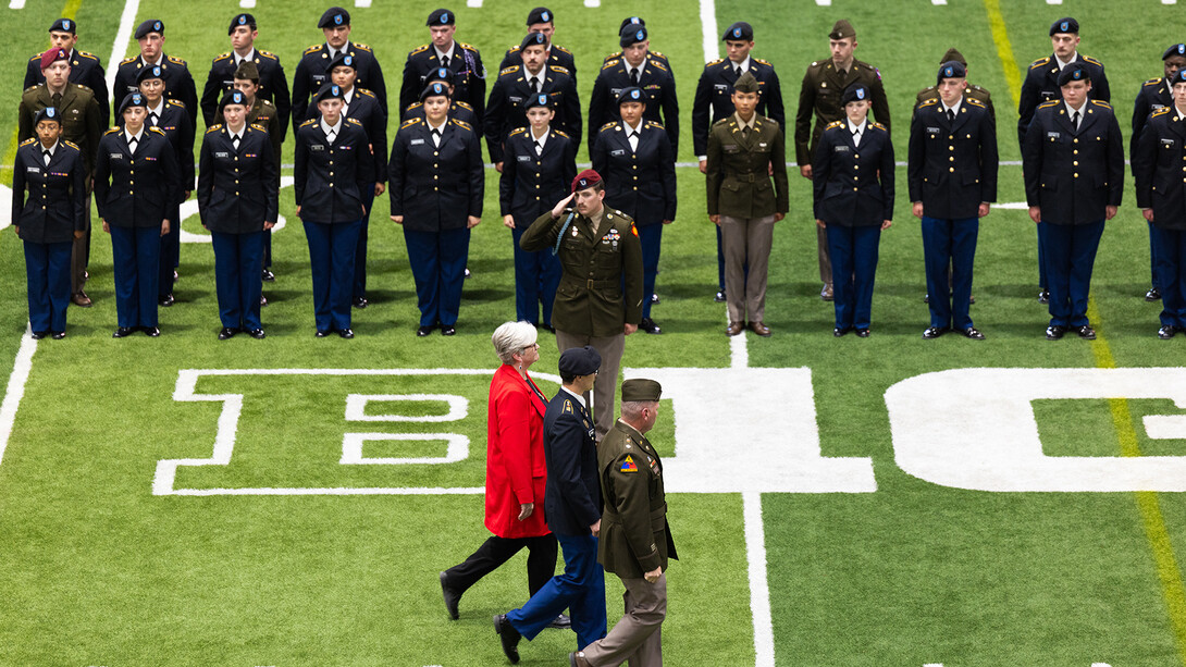 Interim Chancellor Katherine S. Ankerson walks through Cook Pavilion during the Joint Services Chancellor’s ROTC Review at the University of Nebraska–Lincoln, accompanied by Cadet Samuel DuBois and Lt. Col. Thomas Slykhuis, professor of military science, as she inspects cadets from the Army, Air Force, Navy and Marine Corps ROTC programs.