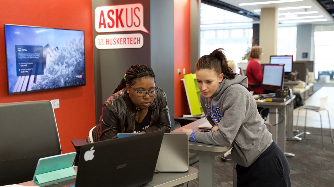 Jasmine Meeks (from left), a member of the Huskertech help desk team, assists Nicole Helm, a junior nutrition and health sciences major, in the new learning commons in Love Library on Nov. 11.