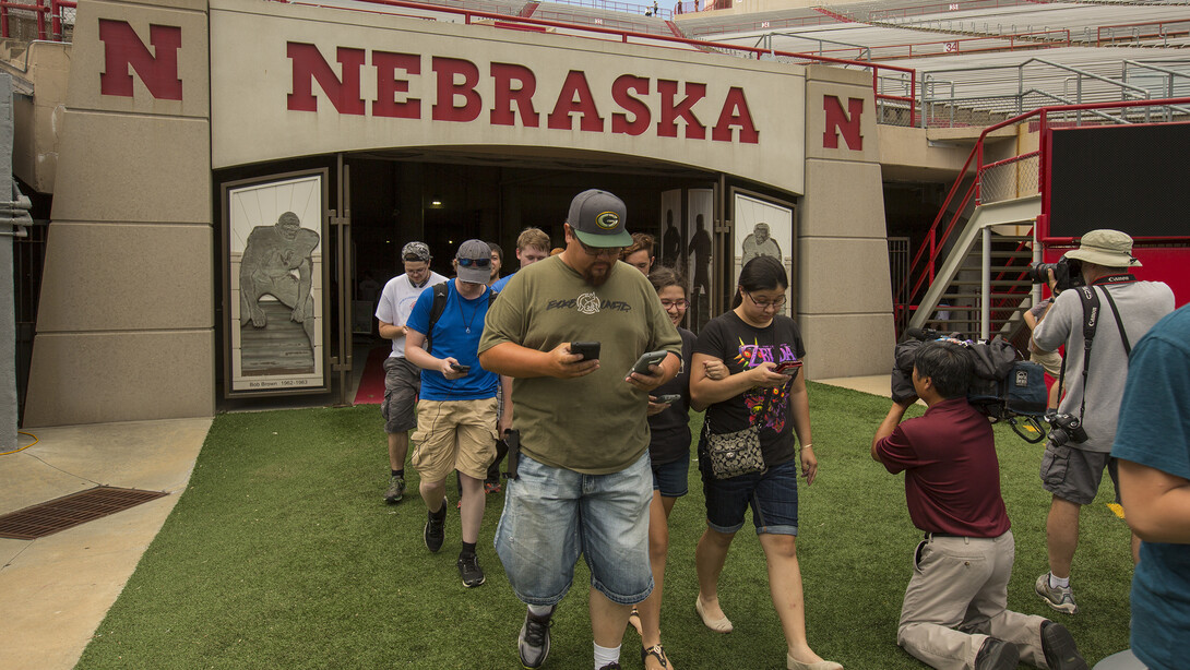 Aaron Shester (front left) and his children lead the Pokémon Go players into Memorial Stadium. The Shesters were the first in line at the event, arriving an hour ahead of the 4 p.m. start time.
