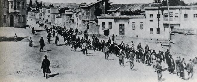 Armenian civilians, escorted by armed Ottoman soldiers, are marched through Harput to a prison in the nearby Mezireh, April 1915.