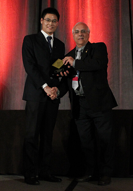 Bin Yang (left) receives a Gold Award from Orlando Auciello, president of the Materials Research Society.