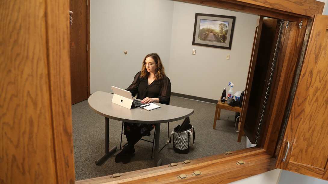 Brenna Lash, a graduate student, loads the Telehealth platform on her laptop computer, as seen from an observation room, where clinic faculty supervisors monitor sessions.